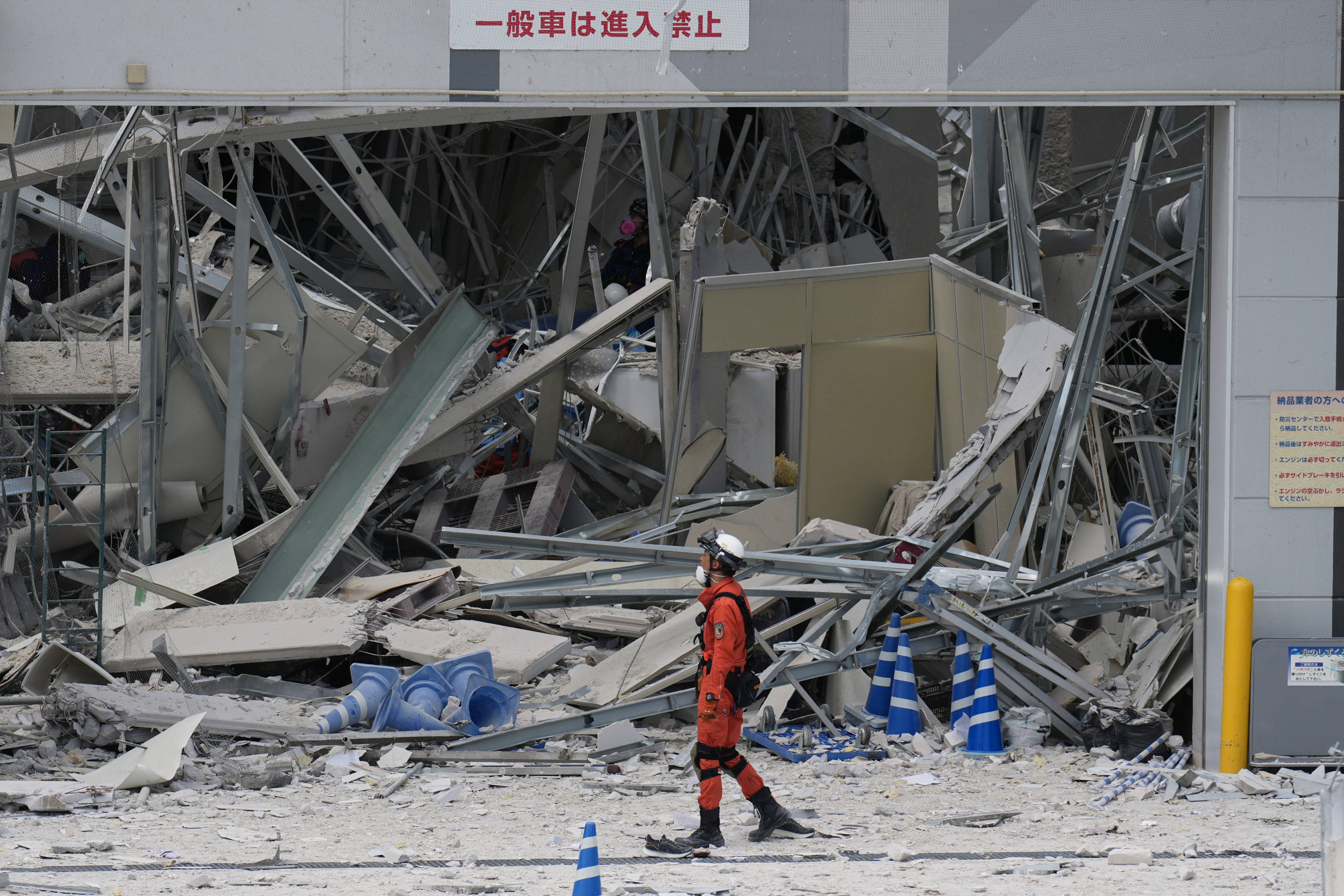 A rescue worker walks in front of Aeon mall in Kashima, Kumamoto, which was damaged by an explosion following an earthquake, on Wednesday. Photo: AP