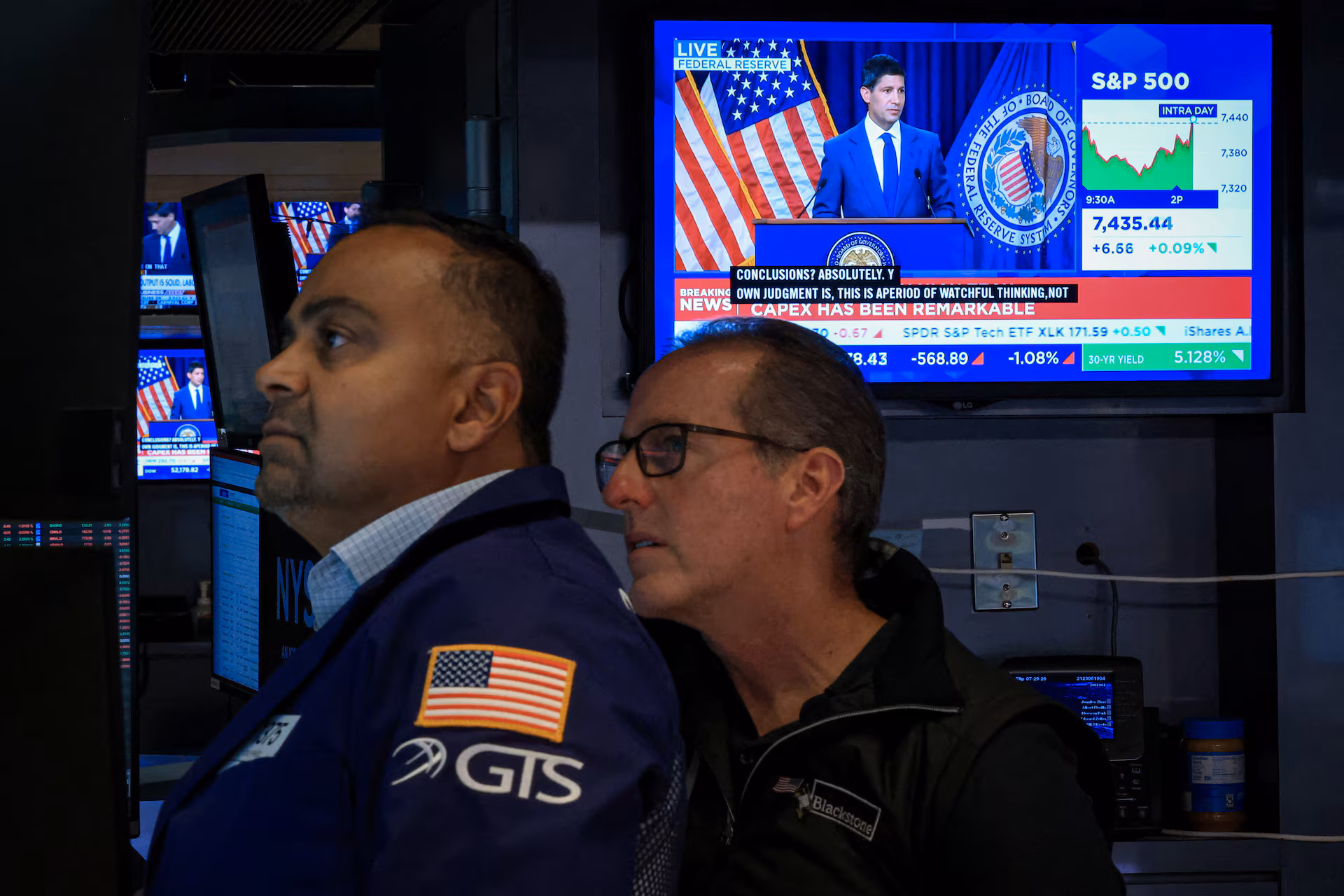 Traders react to the Fed rate announcement on the floor of the NYSE in New York