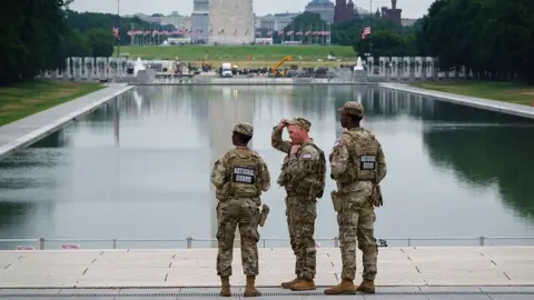 Getty Images Three members of the National Guard stand in front of the Reflecting Pool