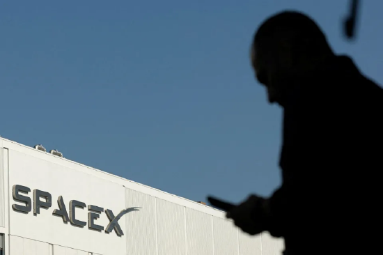 2026 年 6 月 12 日美国加州霍桑市，SpaceX 上市当日，一名员工在前往厂区上班途中看手机
