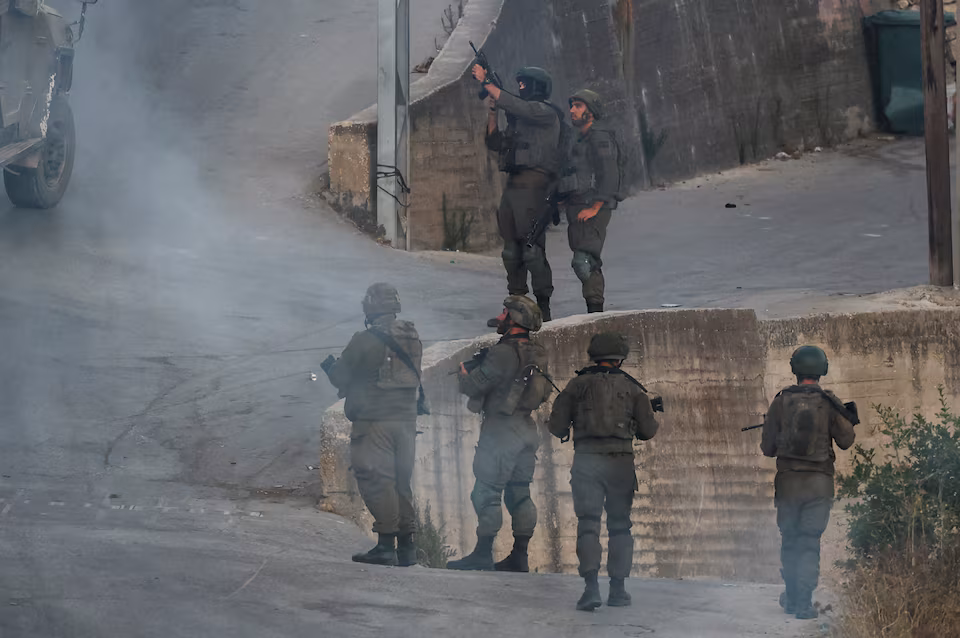 Israeli settlers approach the Palestinian village of Tal