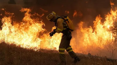 Getty Images A firefighter battles a large blaze