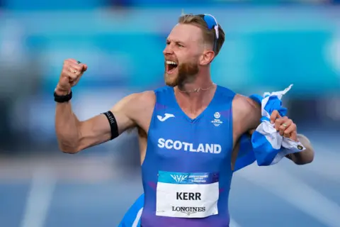Getty Images Mile world record holder Josh Kerr celebrates his Commonwealth title. He looks very happy.