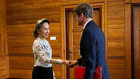 Myanmar Military Information Committee Former Myanmar president Aung San Suu Kyi shakes hands with  Arnaud de Baecque, resident representative of the International Committee of the Red Cross (ICRC)