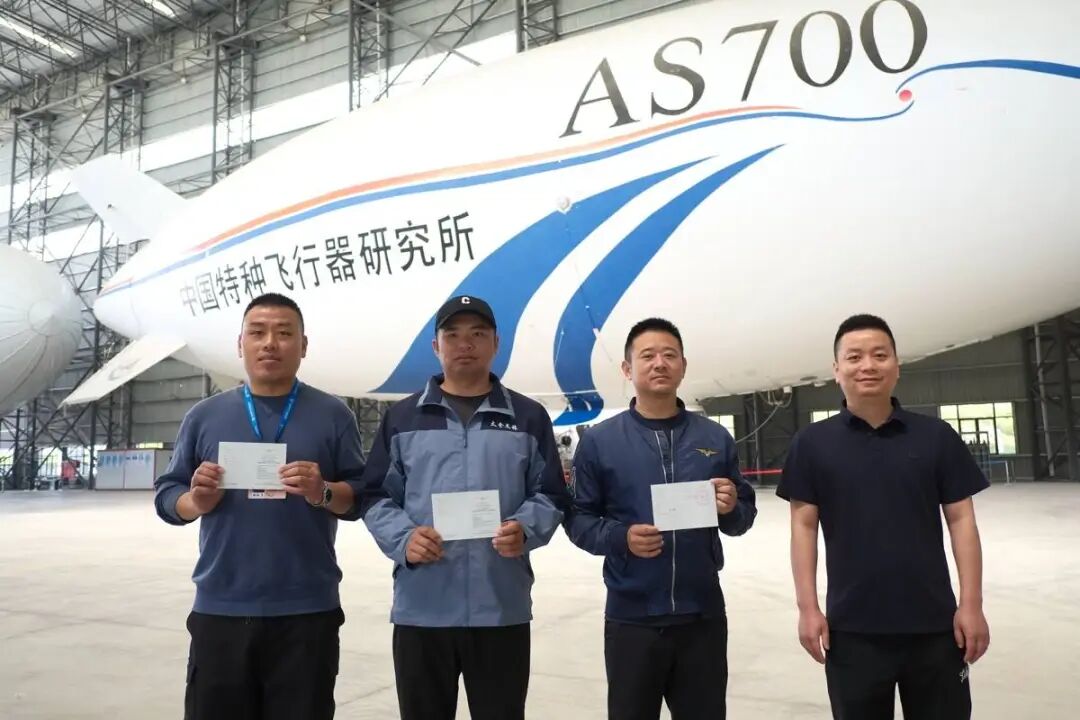 特飞所客服人员为3位飞艇驾驶员送上执照。资料图