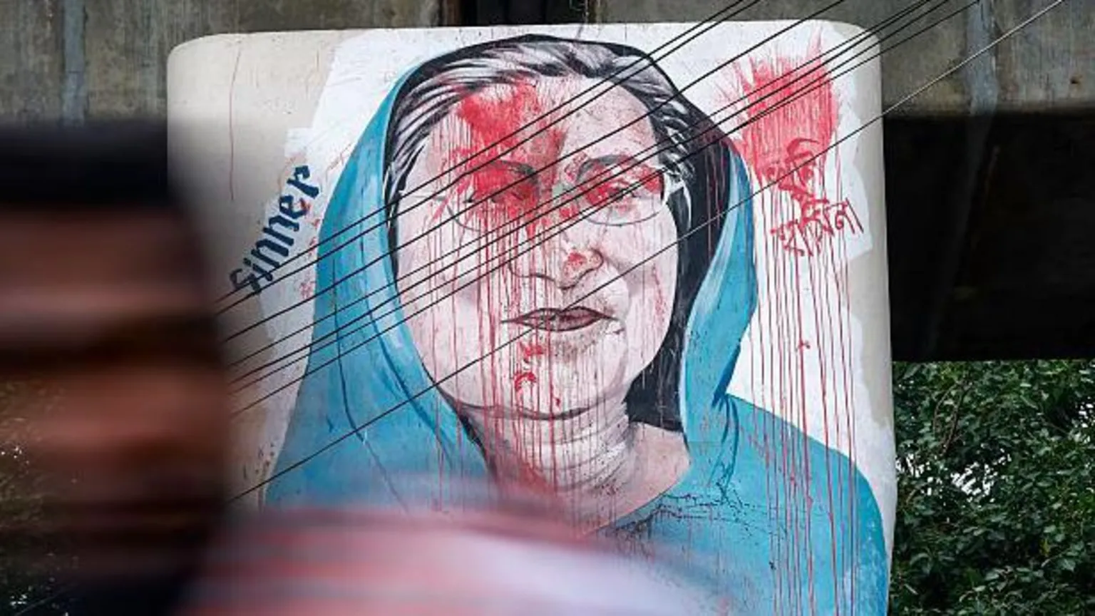 Getty Images Vehicles move past graffiti depicting former Bangladeshi Prime Minister Sheikh Hasina in Dhaka