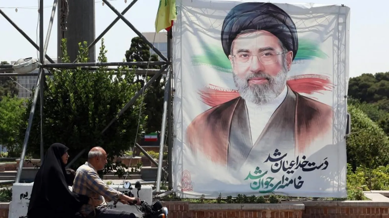 EPA People drive next to a billboard of Iranian supreme leader Ayatollah Mojtaba Khamenei