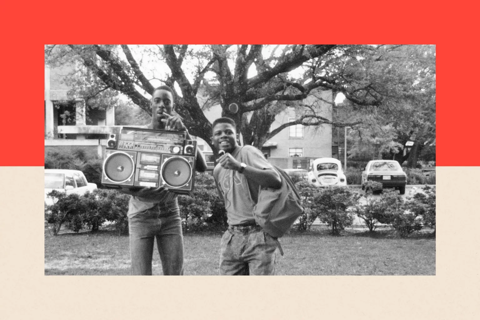 Getty Images Two young men stand by a boombox and smile. The photograph is in black and white