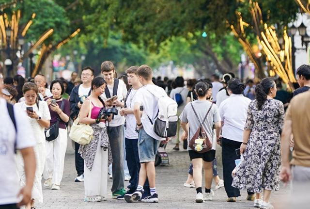 7月22日,外国游客在哈尔滨中央大街参观游览。新华社记者 那宇奇 摄